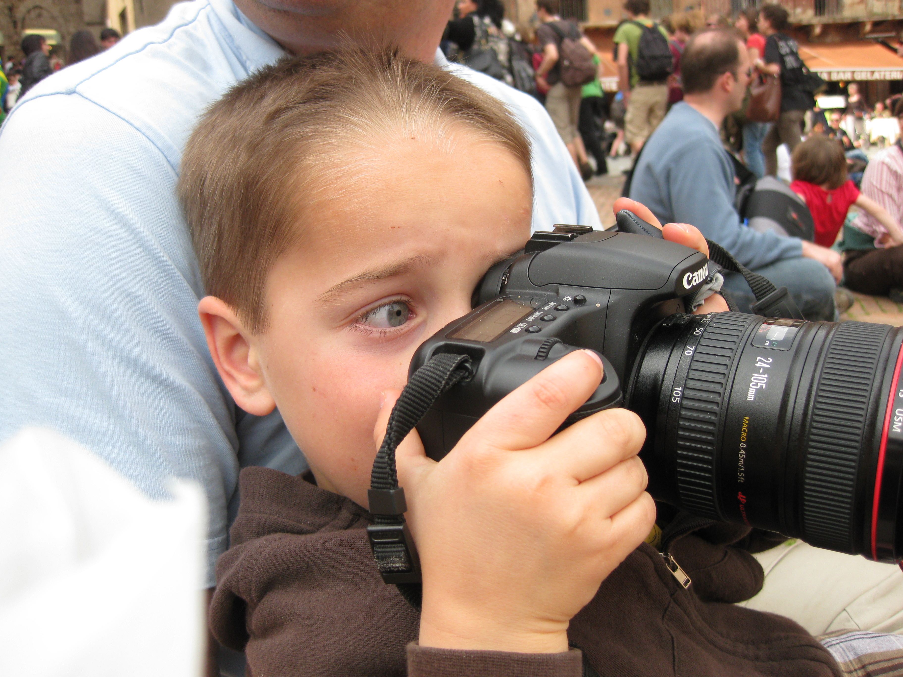 Young Santo as a child looking through a Canon camera for the first time